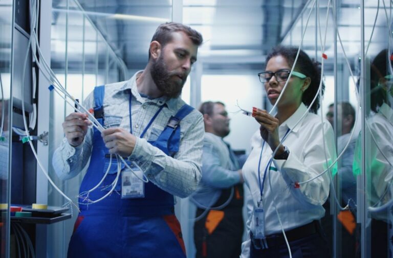 Technician and apprentice working together on mission-critical equipment during hands-on data center training.