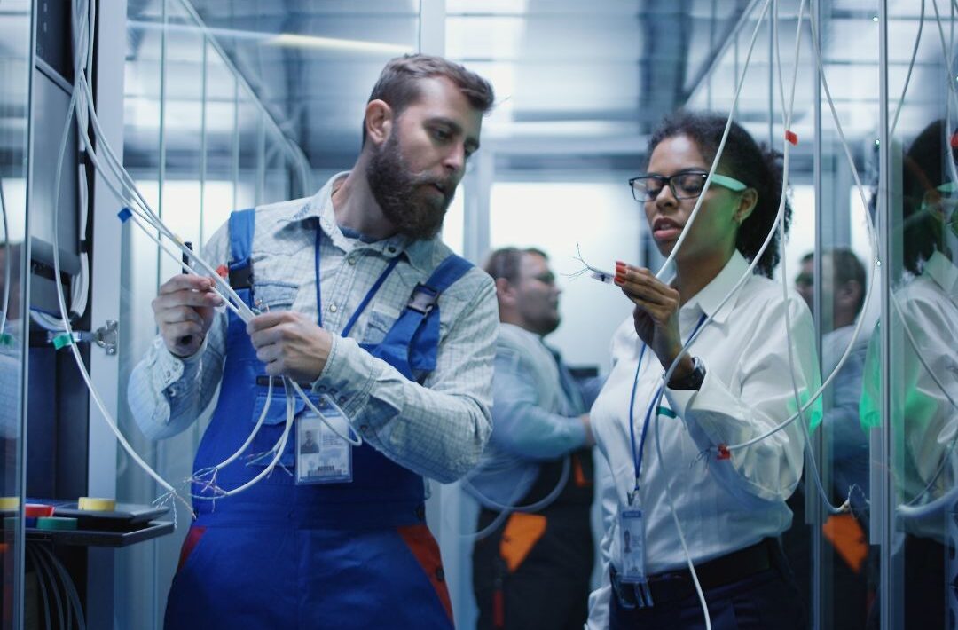 Technician and apprentice working together on mission-critical equipment during hands-on data center training.