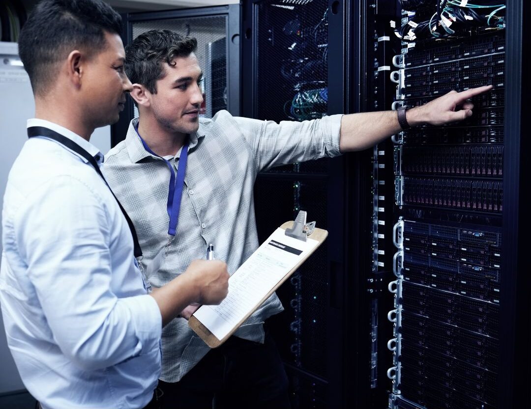 Data center technician walking through server racks, representing contract and full-time workforce models.